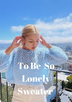 a woman standing on top of a balcony next to a railing with the words, to be so lonelyly sweater