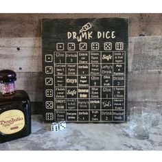 a bottle of liquor sitting next to a game board with dices on the table