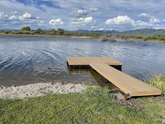 a wooden dock sitting in the middle of a lake