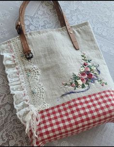 a handbag sitting on top of a table next to a lace doily covered pillow