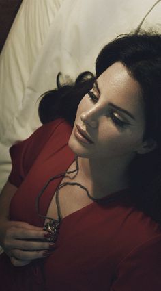 a woman laying in bed wearing a red dress