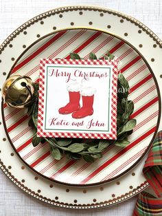 a plate with a christmas card on top of it next to some napkins and bells