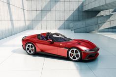 a red sports car is parked in front of a concrete wall and steps that lead up to it