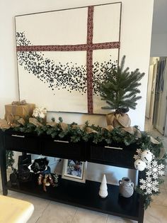 a christmas mantle with presents on it and a cross painted on the wall in the background