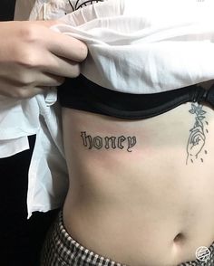 a woman with a tattoo that says honey on her stomach and the word honey written in cursive font