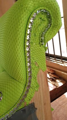 an upholstered green chair with metal rivets