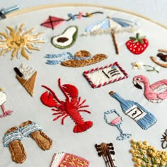 a close up of a embroidery on a white cloth with various types of embroidered items