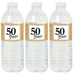 three water bottles with the number 50 years on each one and gold glitter around them