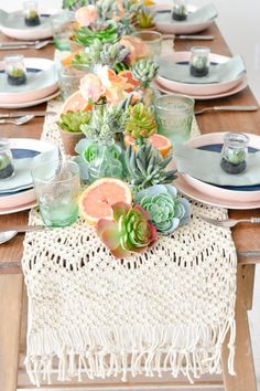 the table is set with succulents and plates