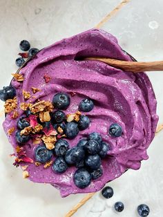 a bowl filled with blueberries and granola on top of a white countertop