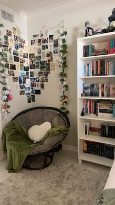 a bed room with a book shelf filled with books and pictures on the wall above it