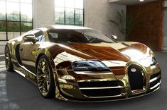 a shiny gold bugatti parked in front of a building