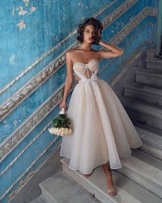 a woman in a dress standing on some stairs