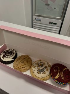 three different types of cookies in a pink box