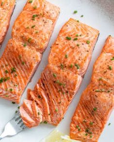 four pieces of salmon sitting on top of a white plate