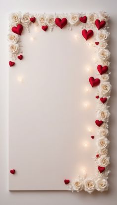 a white sheet with red and white roses on it, surrounded by lights in the shape of hearts