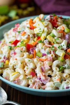 a bowl filled with macaroni salad on top of a wooden table