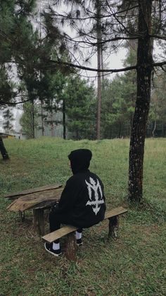 a person sitting on top of a wooden bench