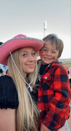 a woman and child with face paint on their faces posing for a photo at an event