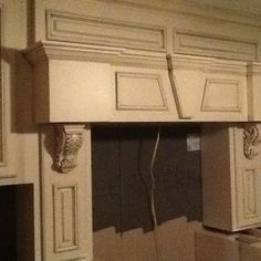 an unfinished kitchen with white cabinets and wood trimmings on the upper part of the cabinet