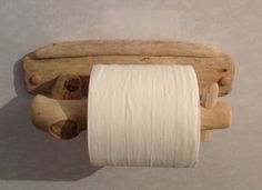 a roll of toilet paper hanging from a wooden holder