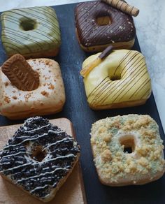 six donuts with different toppings sitting on top of each other