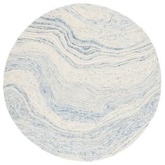 a white and blue circular rug with wavy lines on the bottom, in front of a white background