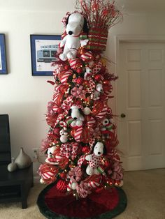 a christmas tree decorated with red and white ribbons, teddy bears and candy canes