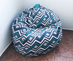 a bean bag chair sitting on top of a tile floor next to a white wall