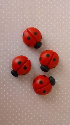 three red ladybugs sitting on top of a white table