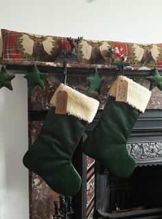 two christmas stockings hanging from a fireplace mantel