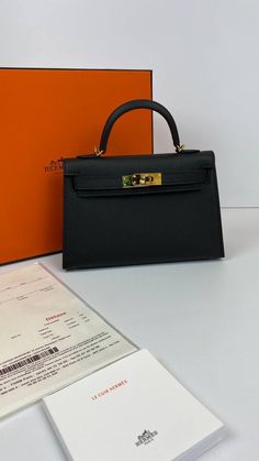 A sophisticated black Epsom leather Hermes Kelly bag with coveted gold hardware.Comes with Hermes signature orange box, shoulder strap and sleeper.d Hermes Kelly 20 Mini bag in classic black.NEW or NOT WEARABLEThe price of the Hermes Kelly 20cm retains its value due to the high demand for this limited style.Last Sale BAG MEASURES:LENGTH 20cm / 8 7/8"TALL 12cm / 4 3/4"DEEP 6cm / 2 3/8" Hermes Kelly Mini 2, Small Hermes Bag, Hermes Handbags Kelly, Hermes Bags Black, Mini Kelly Bag Hermes, Black Hermes Kelly Bag, Hermes Mini Kelly Pochette, Black Kelly Bag, Kelly 20 Hermes