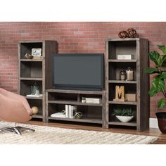 an entertainment center with bookshelves and a television on it in front of a brick wall