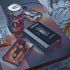 a table topped with cassettes and a can of beer