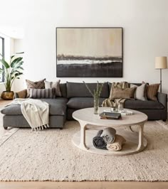 a living room filled with furniture and a large painting on the wall above the couch