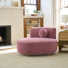 a living room filled with furniture and a fire place in front of a window on top of a rug