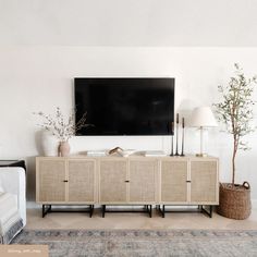 a living room with a large television mounted on the wall