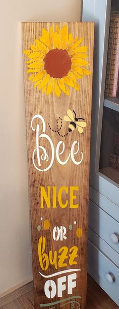 a wooden sign that says bee nice or buzzy off with a sunflower on it