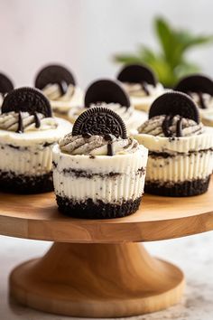 oreo cookies and cream cupcakes on a wooden cake platter for dessert