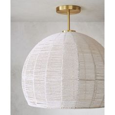 a white and gold light fixture hanging from the ceiling