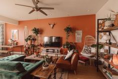 a living room filled with furniture and lots of plants on top of it's shelves