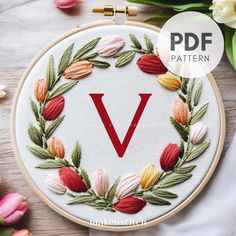 the letter v is surrounded by flowers and leaves on a white background with text overlay