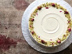 a cake with white frosting and pink flowers on the top is sitting on a plate