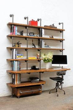 a computer desk sitting in front of a bookshelf