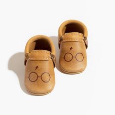 a pair of baby shoes with glasses drawn on them