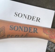 a person with a tattoo on their arm and the words sonder next to it