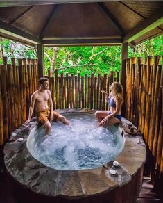 a man and woman sitting in a hot tub