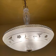 a white chandelier hanging from a ceiling in a room with a light fixture