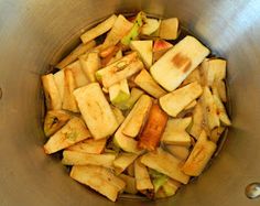 apples are in a metal bowl with spoons