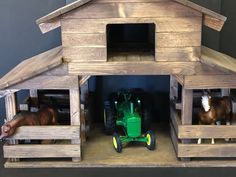 two horses and a tractor in a wooden stable